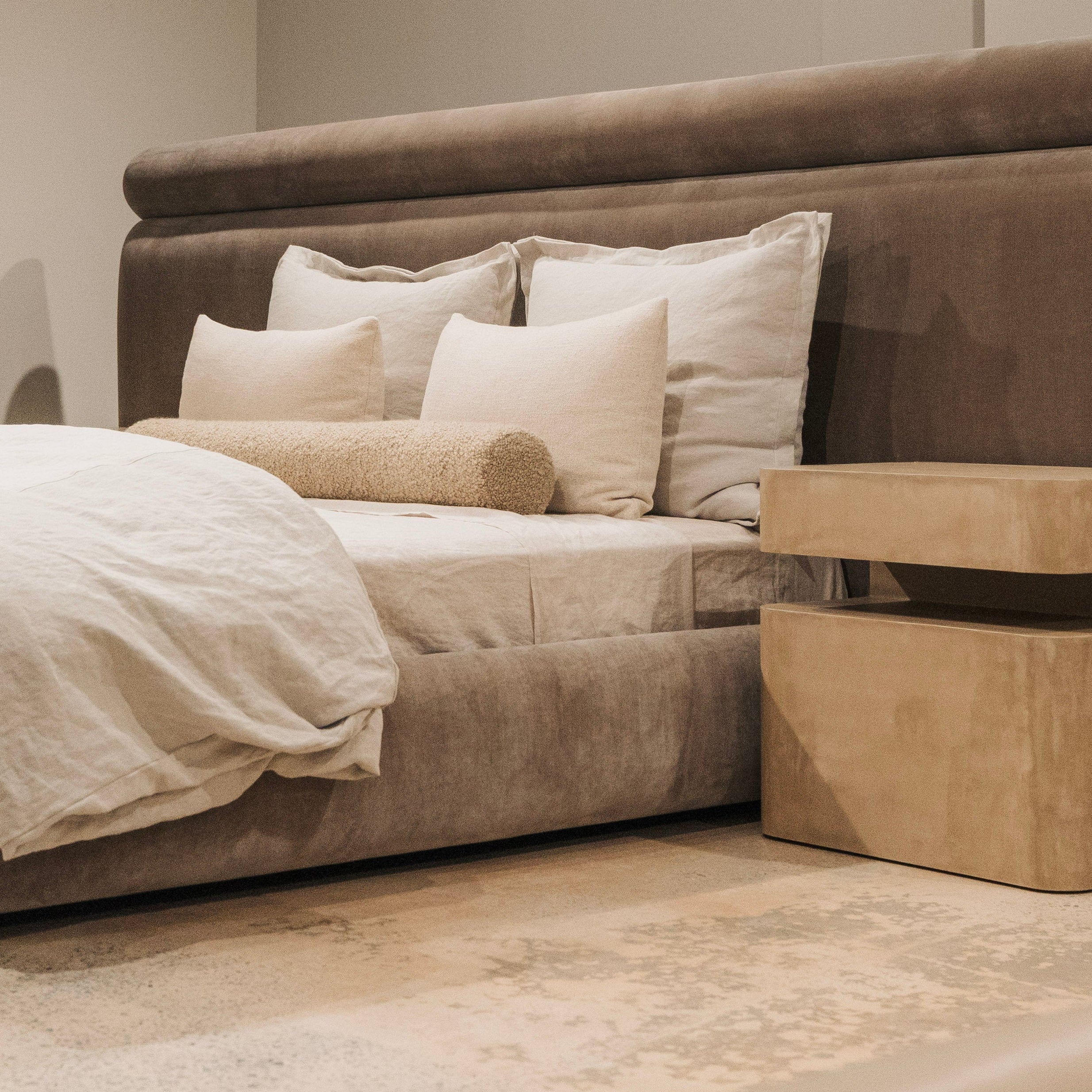 Beige bedroom with a large bed and matching nightstands.