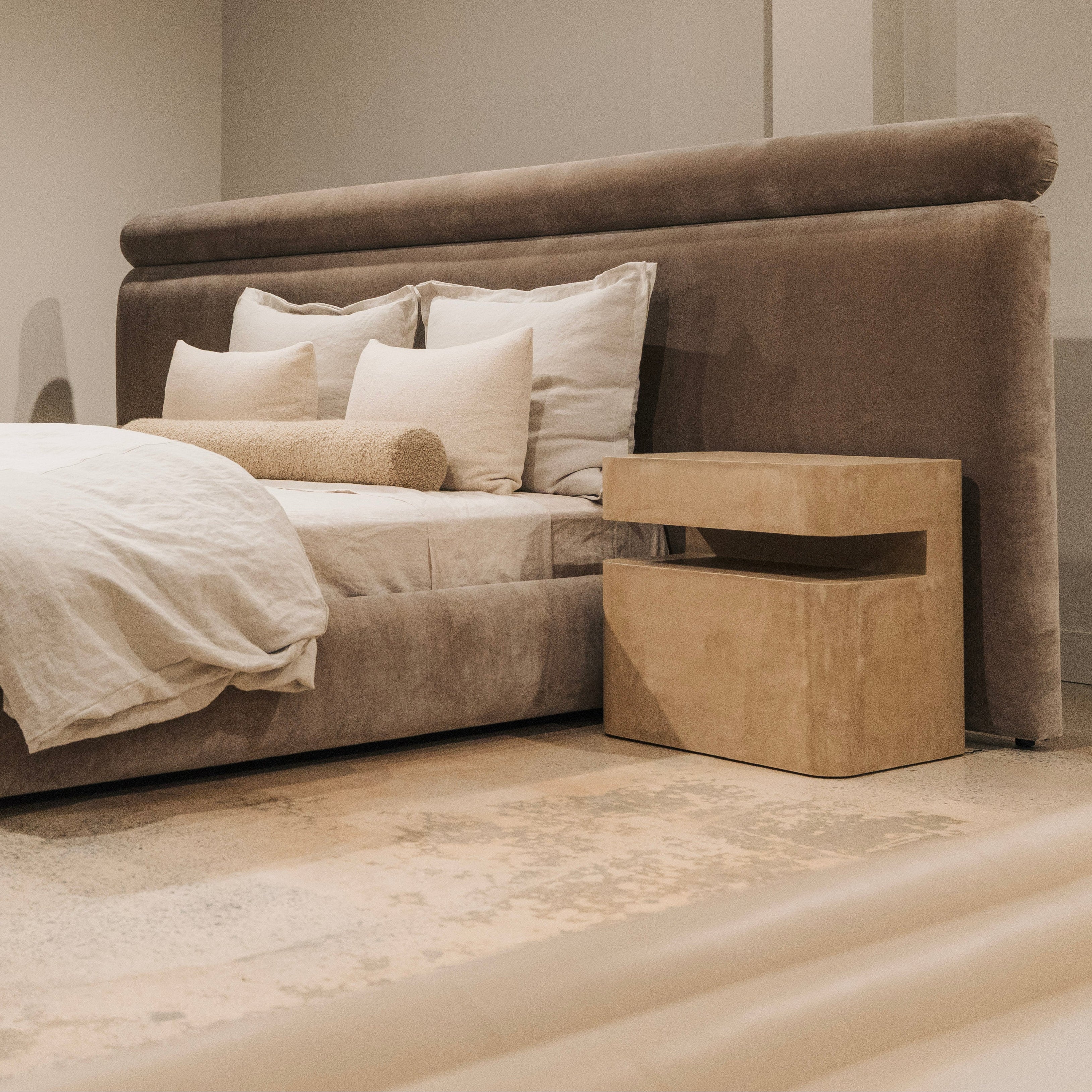Beige bedroom with a large bed and matching nightstands.