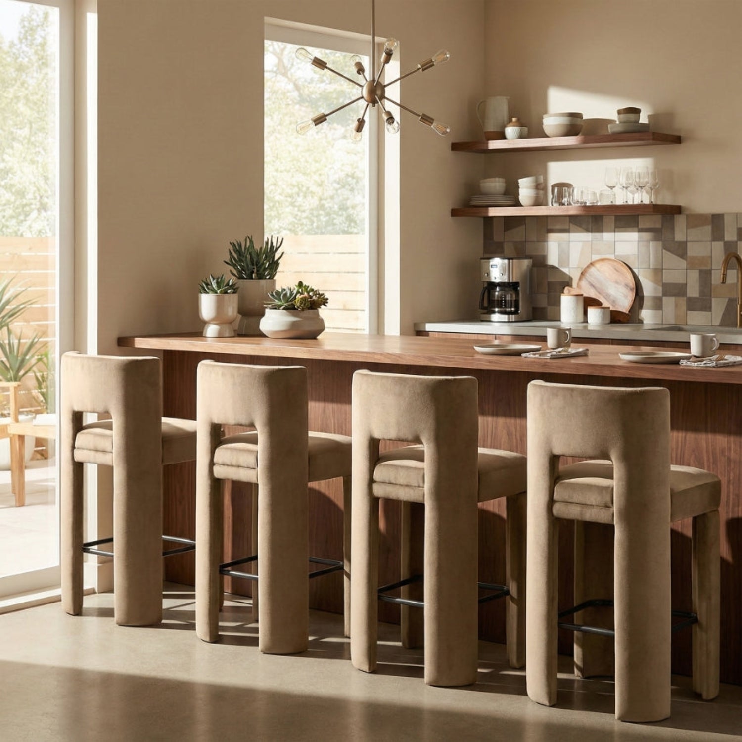 Modern kitchen with wooden dining table and beige chairs, featuring a coffee maker and shelves with decor items.