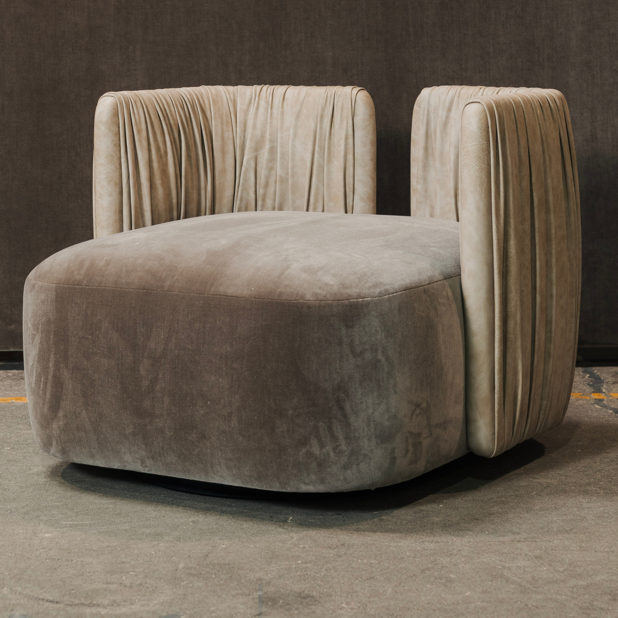 Modern beige accent chair with a textured surface on a dark background. Leather ruching details on back.