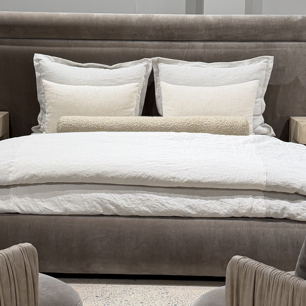 Modern bedroom with a large bed, armchairs, and nightstands.