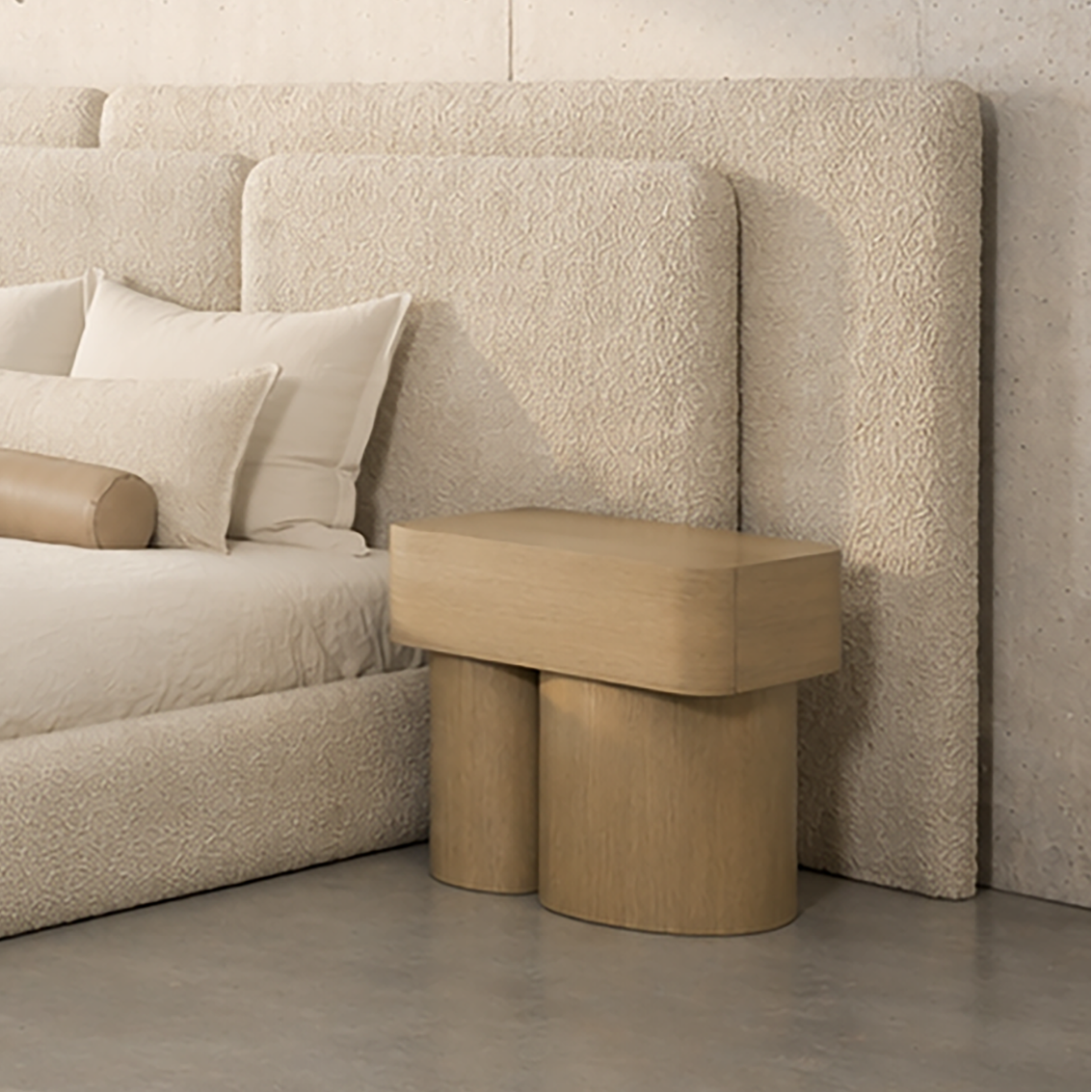 Modern bedroom with a large bed and side tables against a concrete wall.