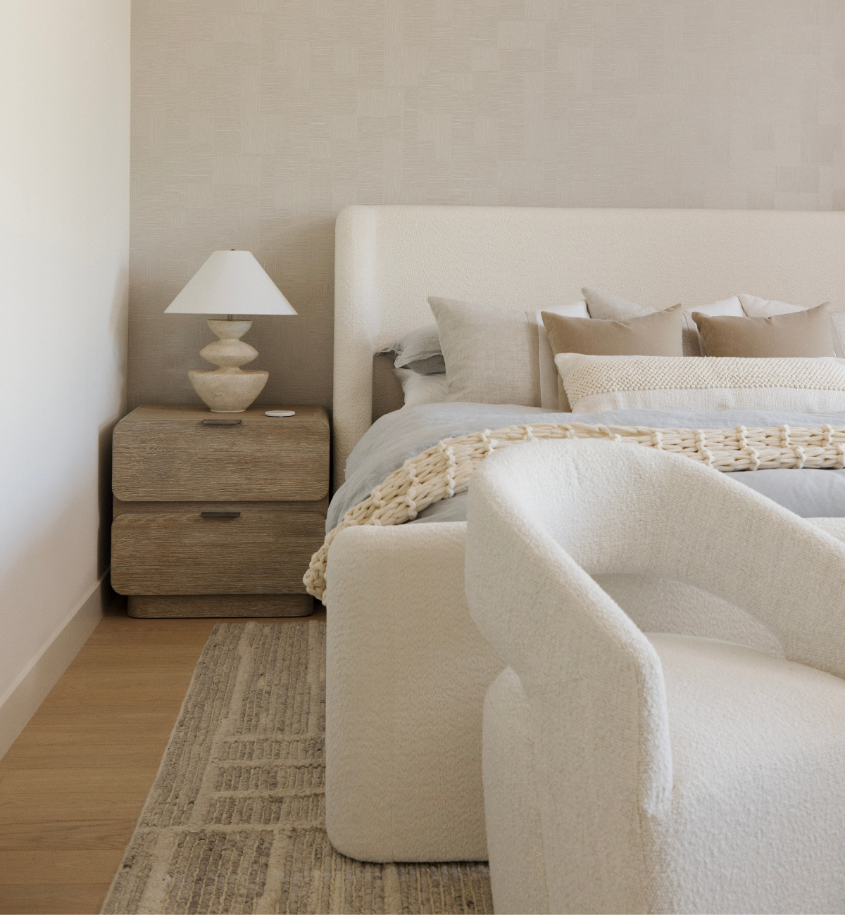 Modern bedroom with a bed, nightstand, and lamp.