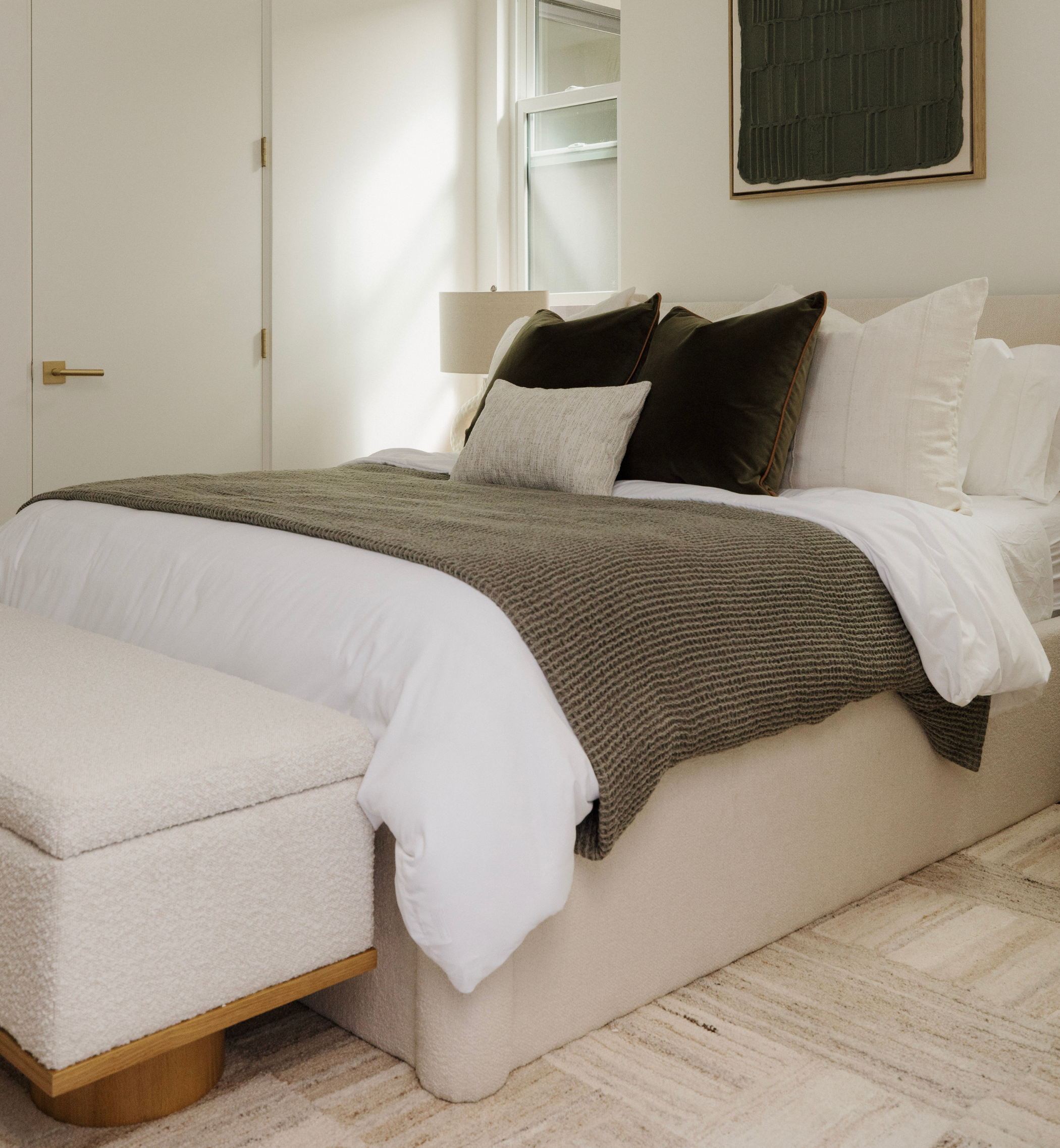 Neatly made bed with brown and white bedding in a bedroom setting.