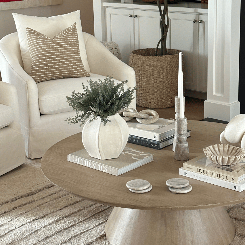 Living room with a round wooden coffee table, armchair, and fireplace.
