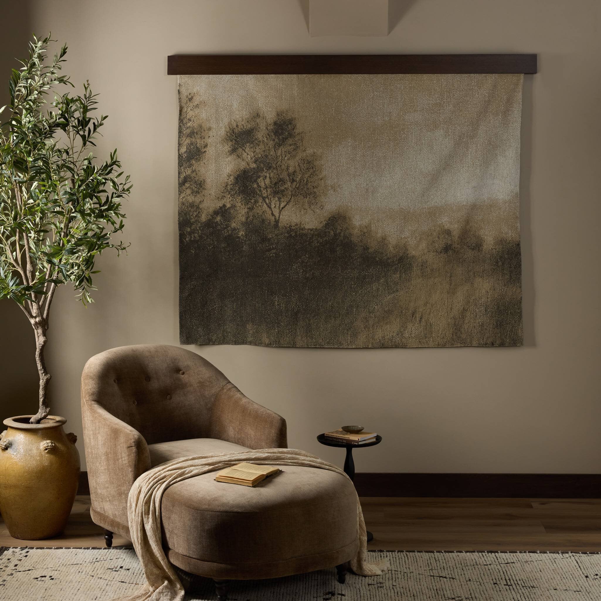 Cozy living room with a brown armchair, plant, and wall art.