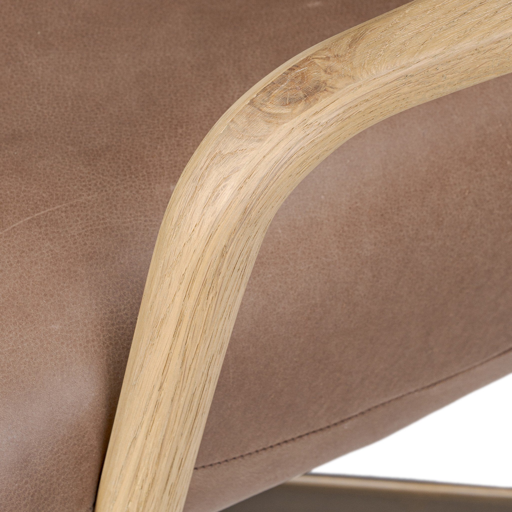 Close-up of Sammy Desk Chair's curved light oak paddle arm with wood grain.