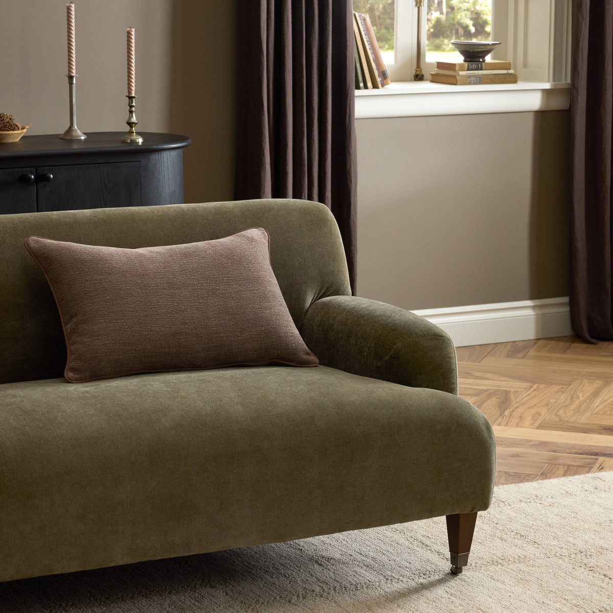 Vanna Pillow styled on a green upholstered chair beside a window