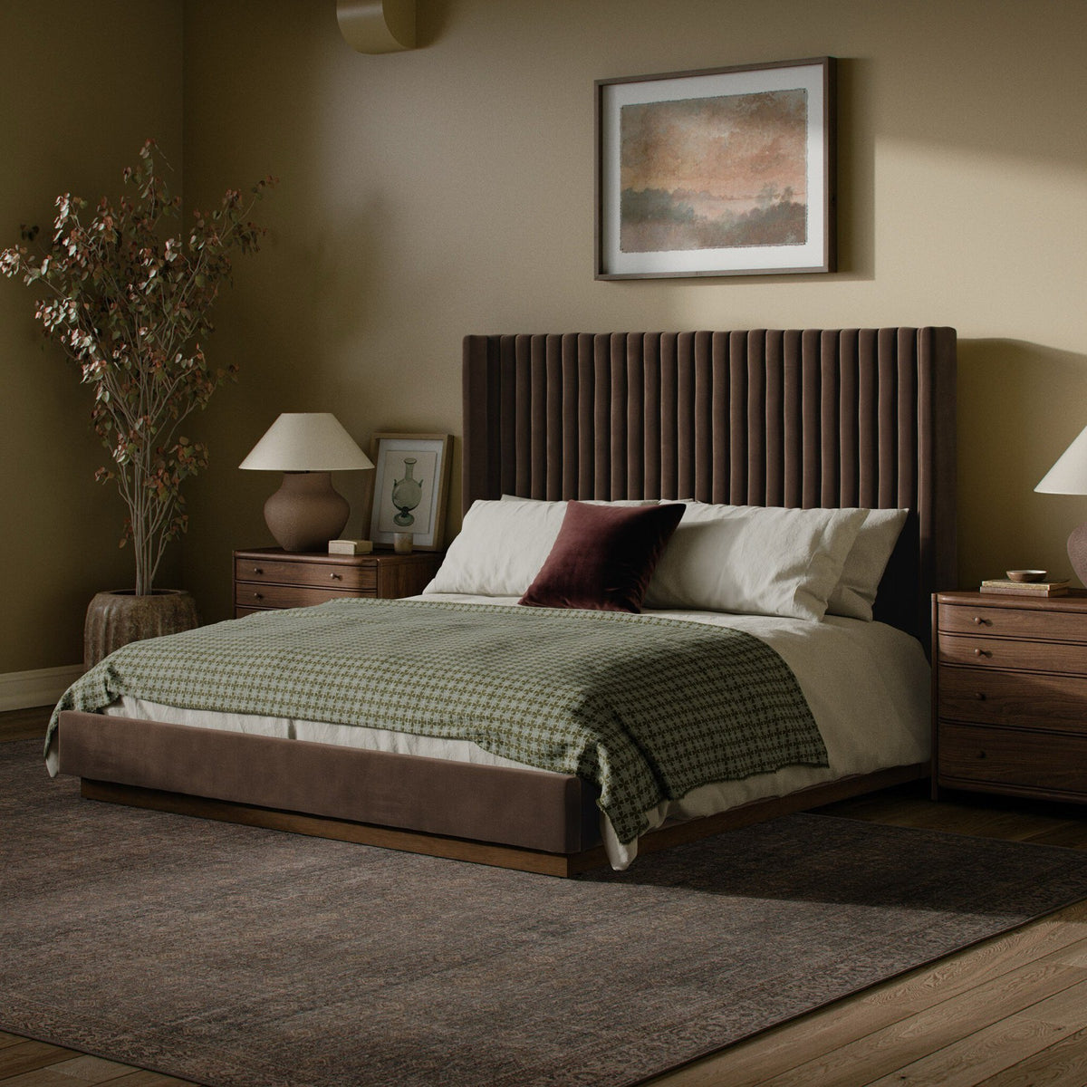 Camel leather sofa with a ribbed round coffee table, burgundy flowers, and layered seating.