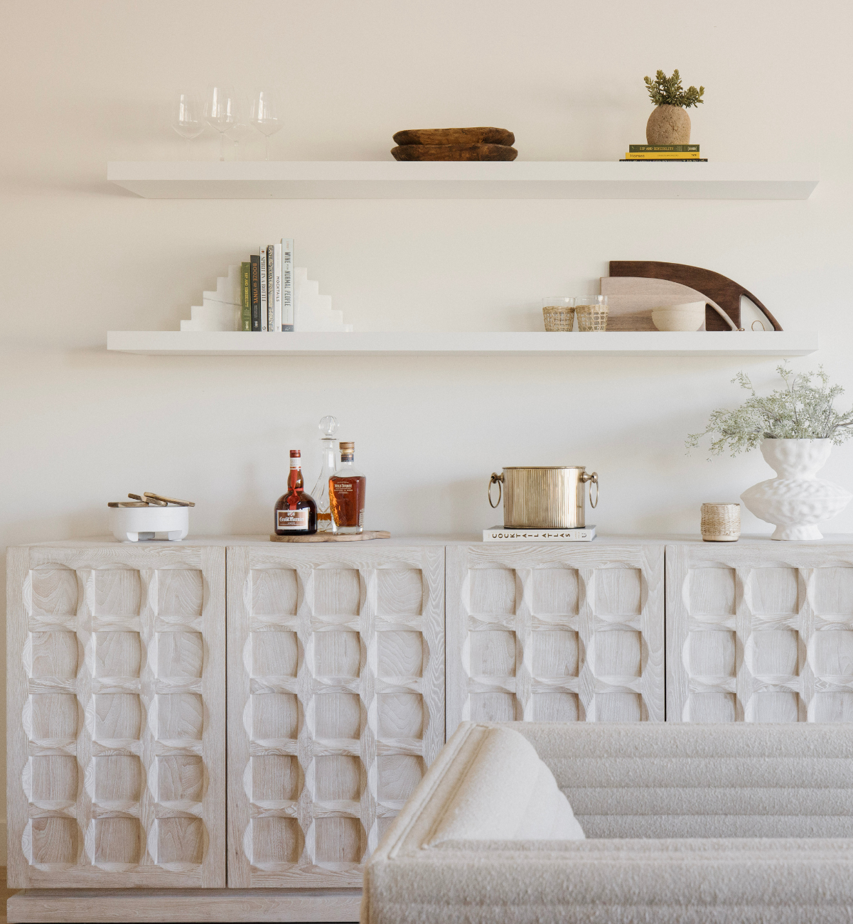Modern interior with textured wall, shelves, and a sofa.