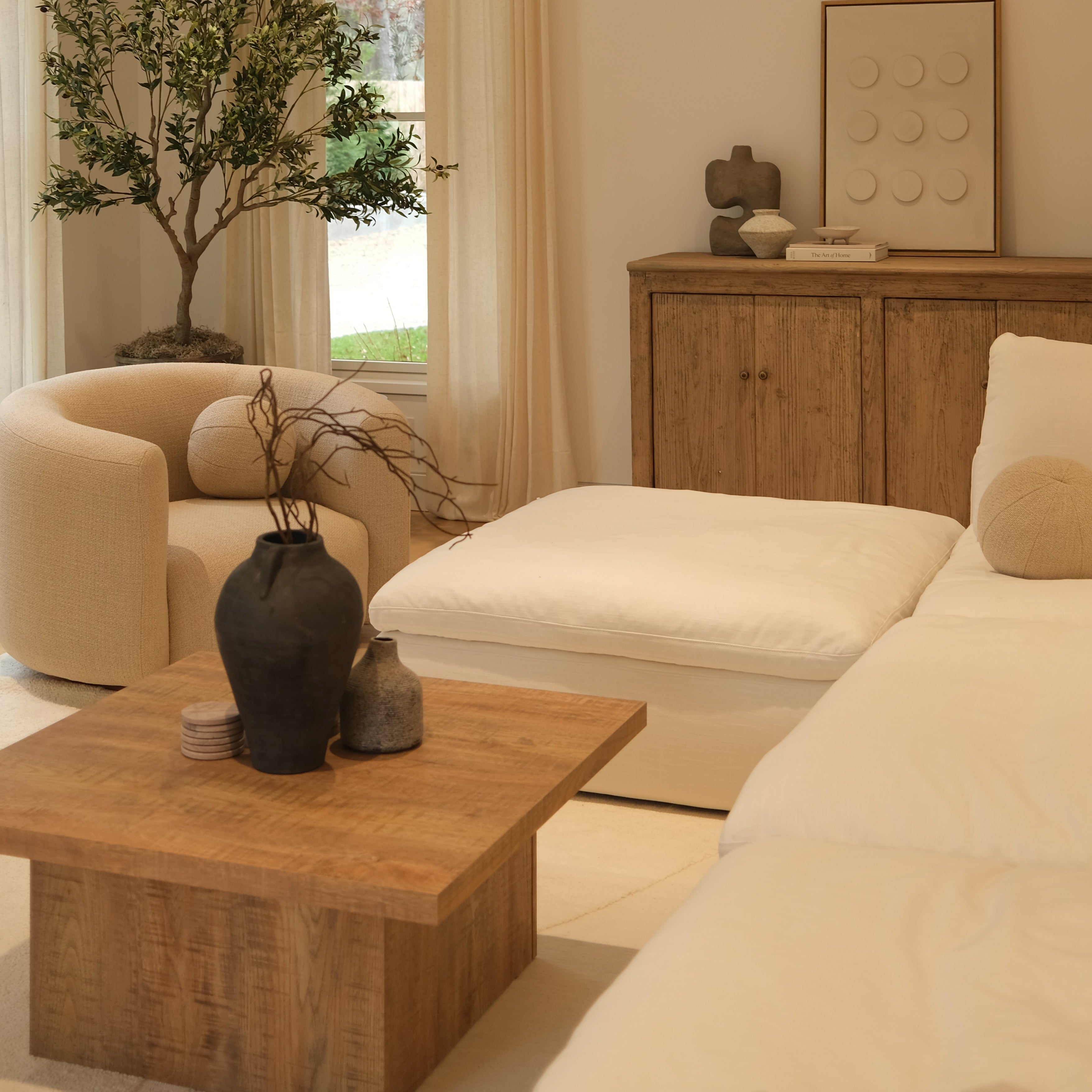 Living room with beige sofa, wooden coffee table, and decorative items.