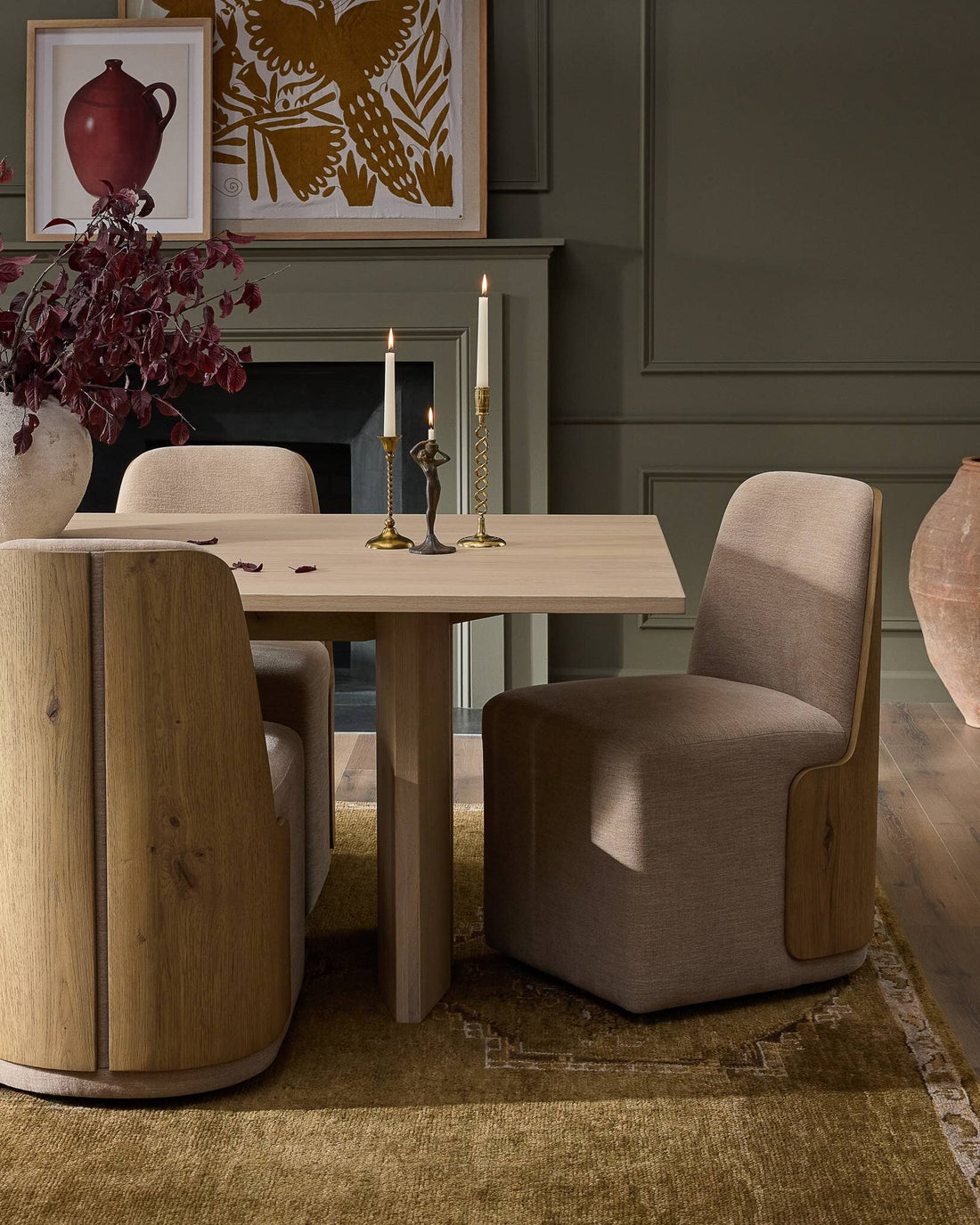 Dining room with wood table, upholstered chairs, and artwork