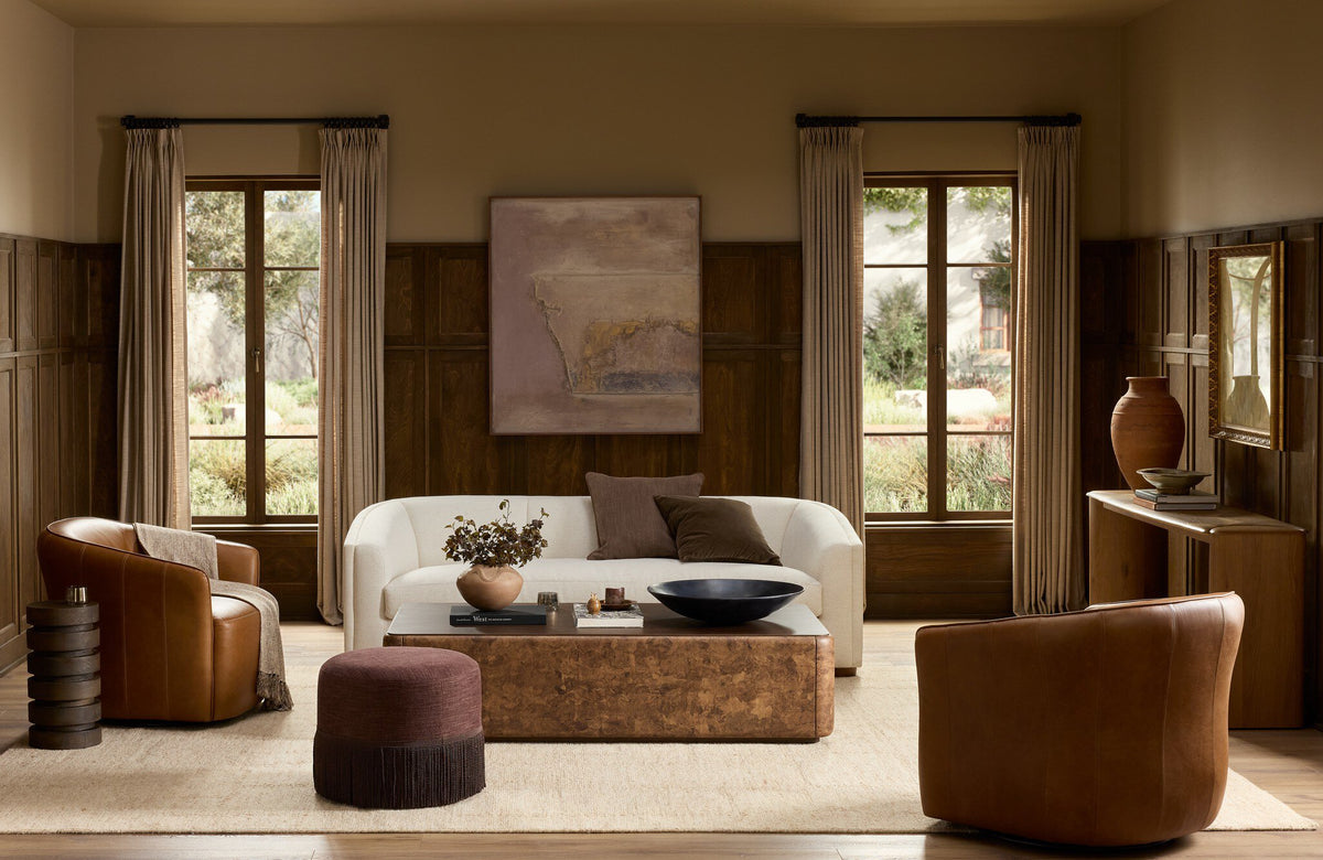 A panelled living room with cognac chairs, a cream sofa, and a broad coffee table, by StyleMeGHD.