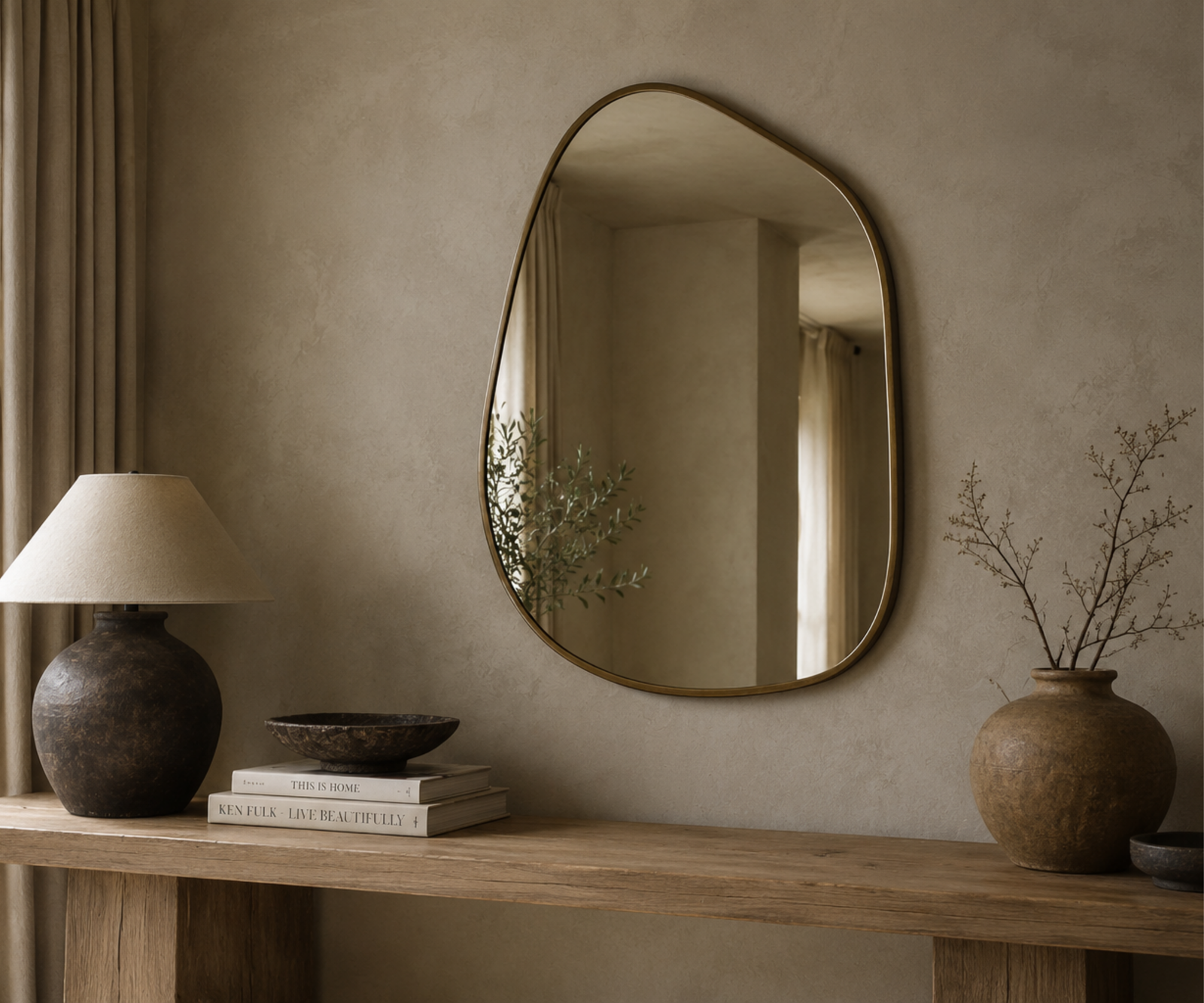 Organic shaped mirror on a limewash wall in a wabi sabi home.
