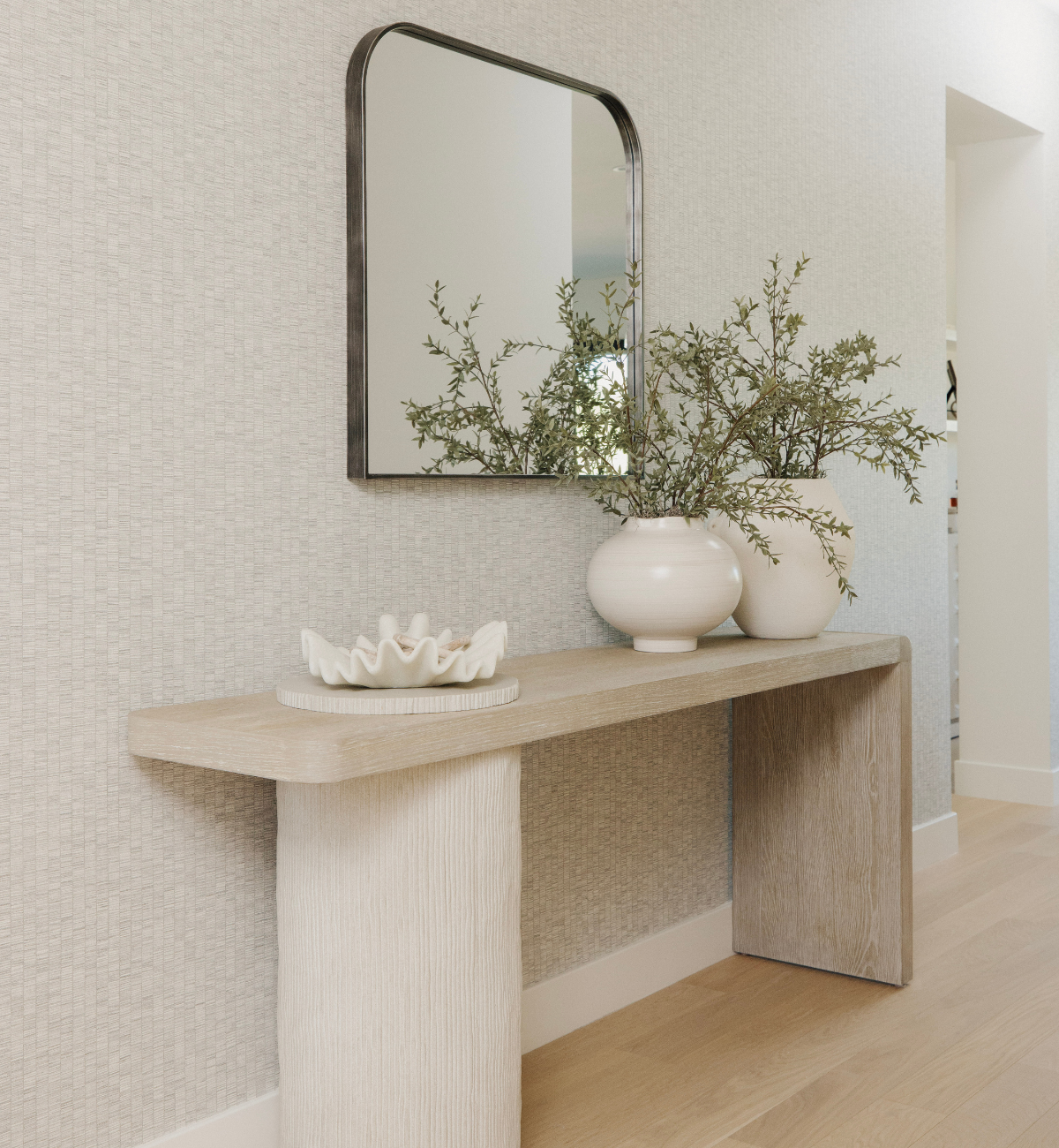 Console table with decorative items against a textured wall