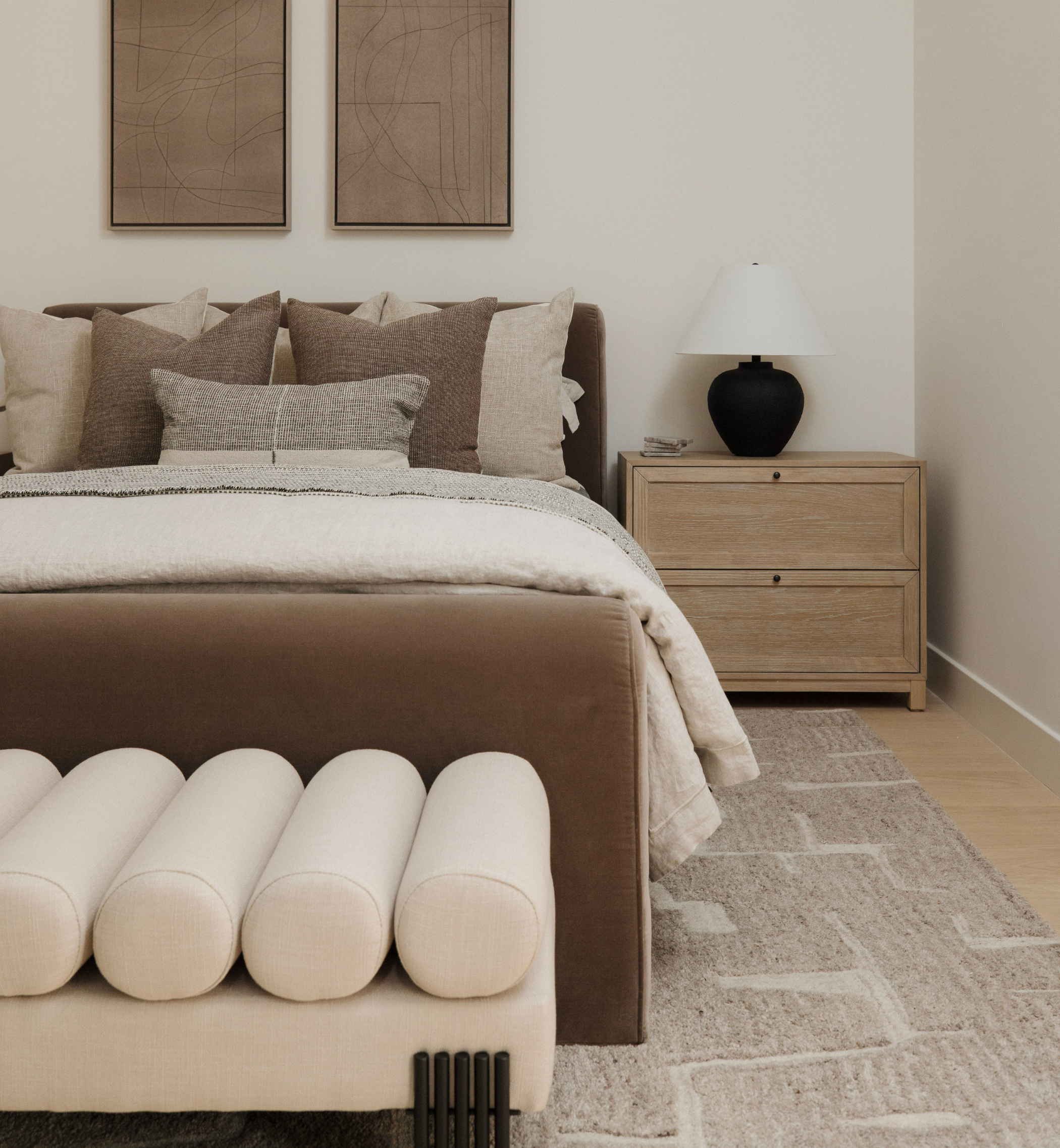 Neatly made bed with decorative pillows in a bedroom setting.
