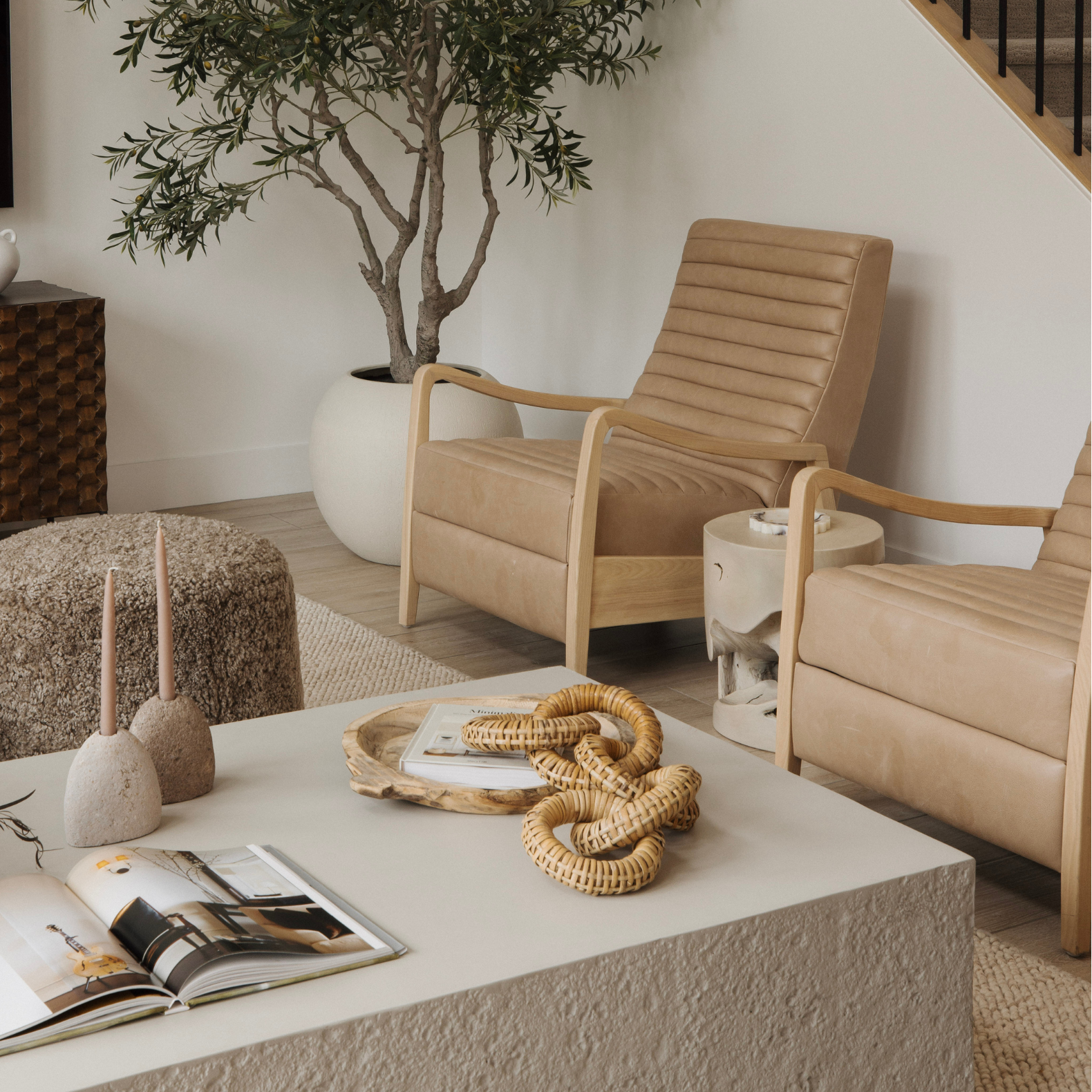 Modern living room with beige armchairs, a coffee table, and decorative items.