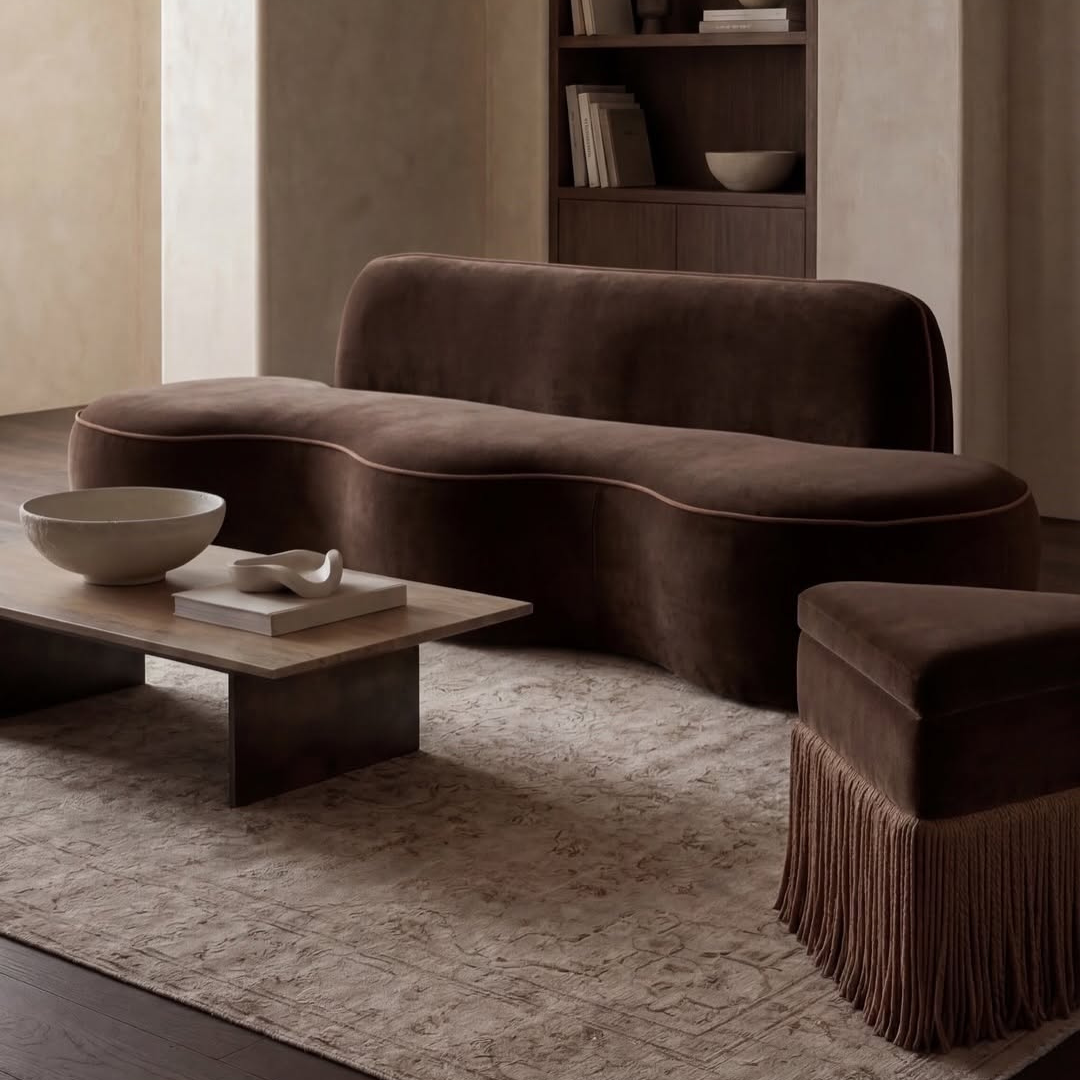 Modern living room with a brown curved sofa and a coffee table.